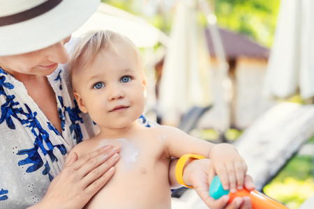 Woman applying cream on a toddler