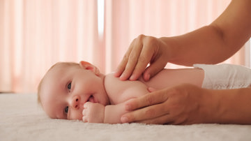 Woman massaging a baby